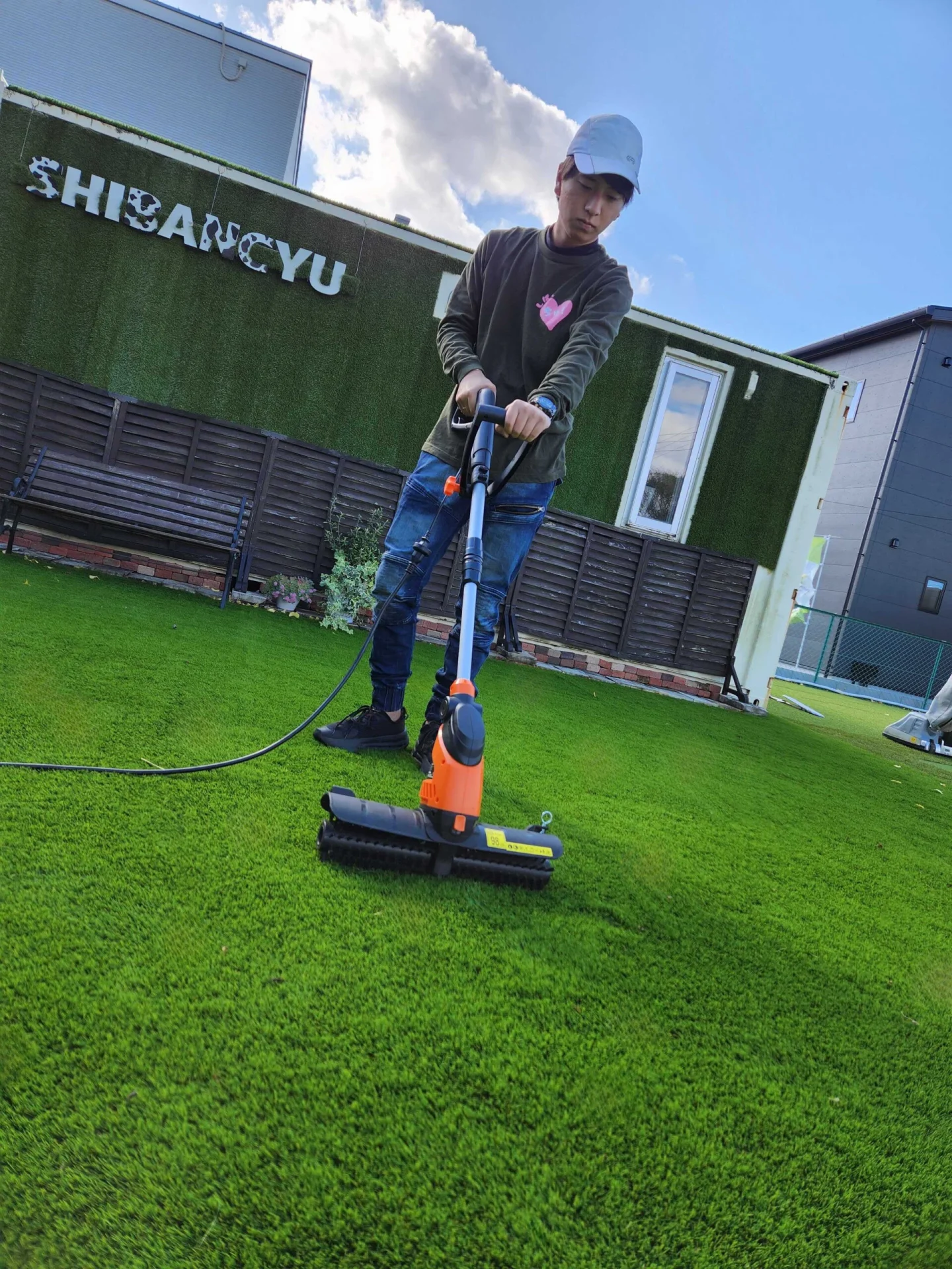 人工芝を清掃する男性